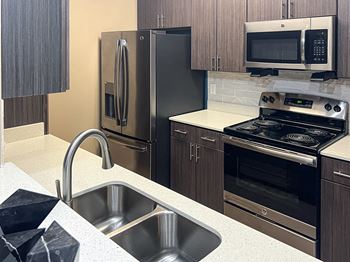A kitchen with stainless steel appliances and wooden cabinets